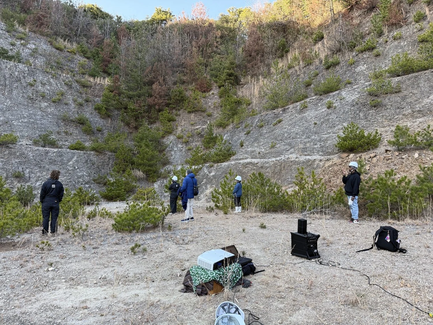 Participants explore the former Shiroyama quarry site during an environmental art field visit in Himeshima, Oita.／大分県姫島村の城山採石場跡地で、環境と関わるアートの現地調査に参加する人々。