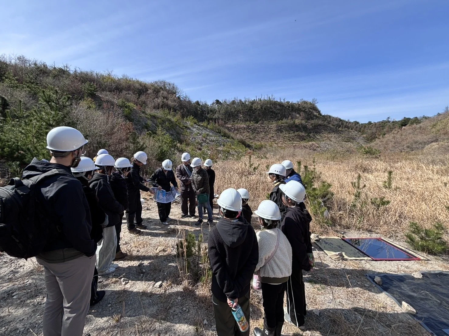 Participants walk through the Shiroyama quarry landscape during HIMESHIMA GEO–OASIS, a field-based art, geology, and community learning project. 姫島「ジオ・オアシス」で、参加者が城山採石場跡地を歩きながら、アート、地質、地域の学びを深めている様子。