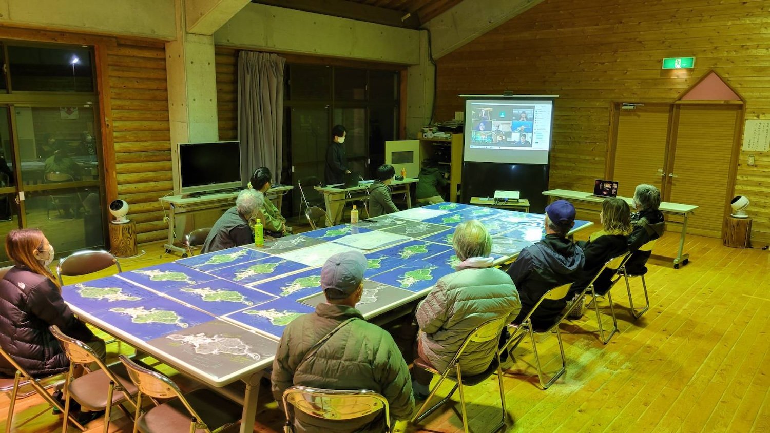 Himeshima residents gather around Island Atlas maps during a community dialogue and presentation in Oita.／大分県姫島村で、「島のアトラス」の地図を囲み、発表と対話に参加する島民の皆さん。