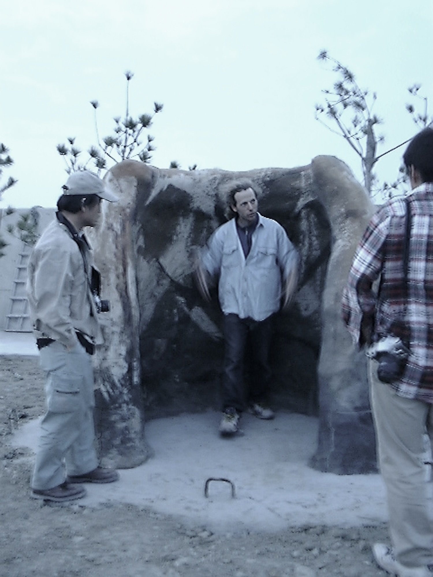 People standing within and around the fired-clay form of Plaza de Sora, experiencing the work at human scale. / 焼成された《空の広場》の内部や周囲に立ち、身体的なスケールで作品を体験する人々。