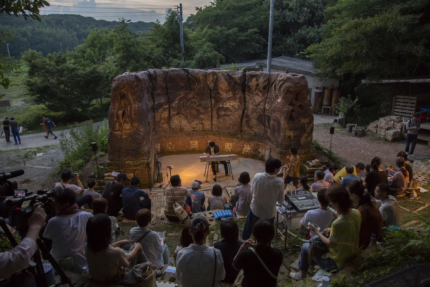 Audience gathered for an outdoor performance at The Mountain Plaza ceramic amphitheater in Mihama, Aichi.／愛知県美浜町の山の広場®焼物野外劇場に集まり、野外公演を鑑賞する人々。