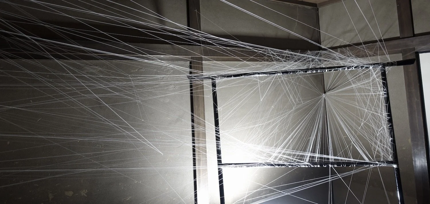 String Memory installation at the Former Nakano Hanroku Residence, with numerous threads extending across the historic interior and doorway. / 旧中埜半六邸の室内と開口部を横切る多数の糸によって構成された《String Memory》の展示風景。