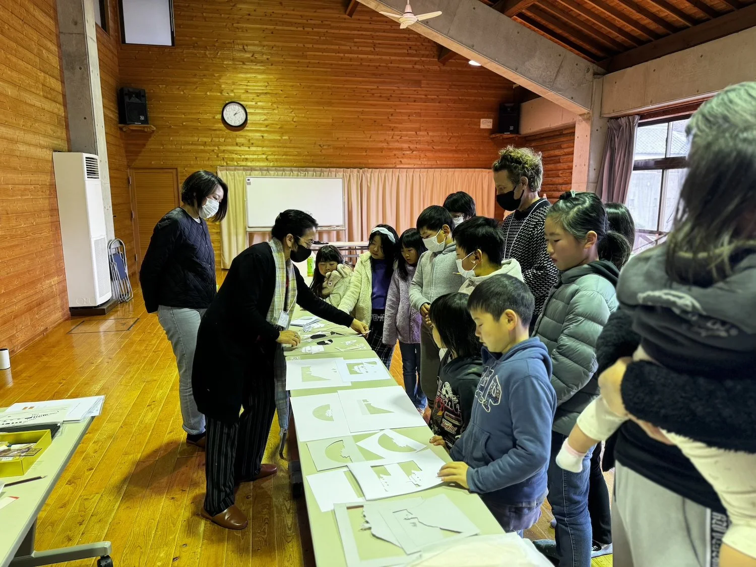 Children and adults take part in a Himeshima WAKU WAKU workshop, sharing ideas, materials, and local island experiences. 姫島わくわく交流のワークショップで、子どもと大人がアイデアや素材、島での体験を共有している様子。
