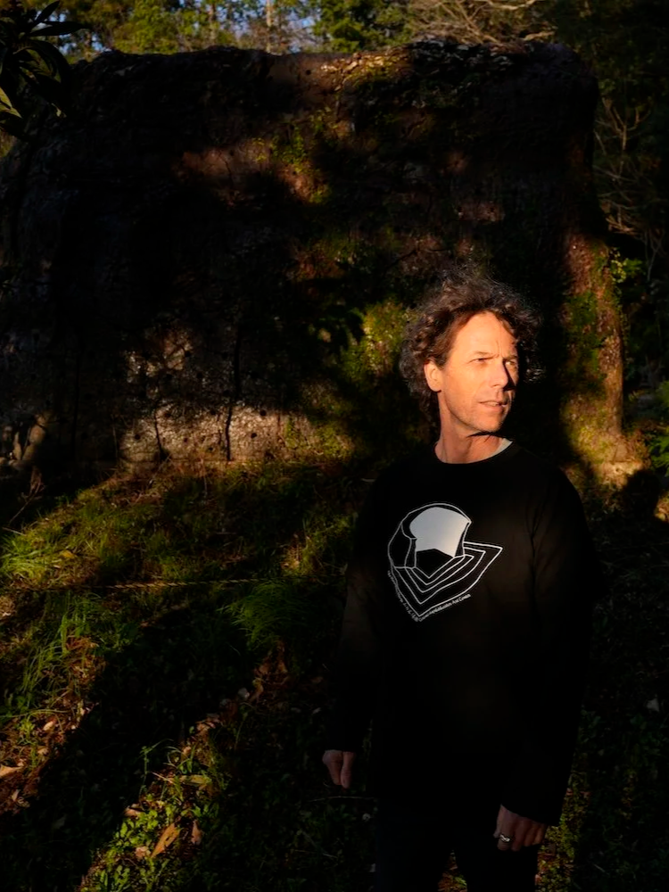 Portrait of Steven (Elgueda Ward Studio co-founder) standing in the wooded landscape of The Mountain Plaza in Mihama, Aichi.／愛知県美浜町の山の広場®の林の中に立つElgueda Ward Studio共同代表のポートレート。