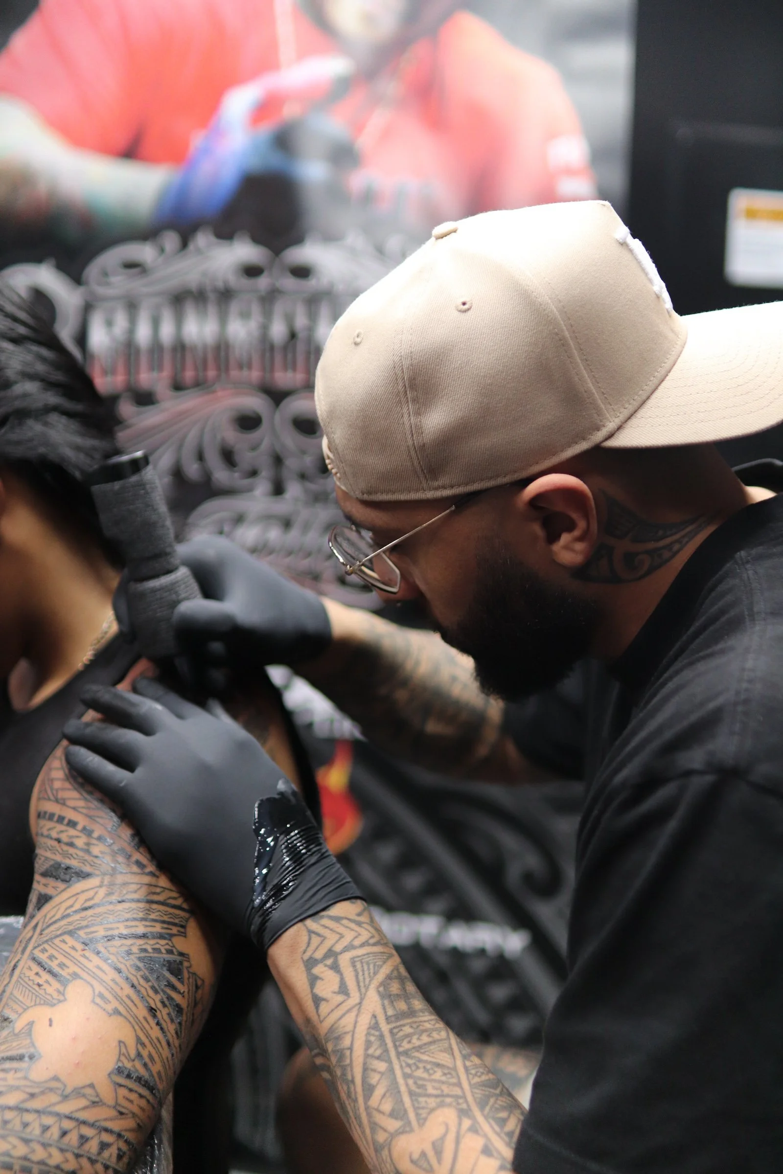 Tattoo artist tattooing a person's arm in a tattoo studio.