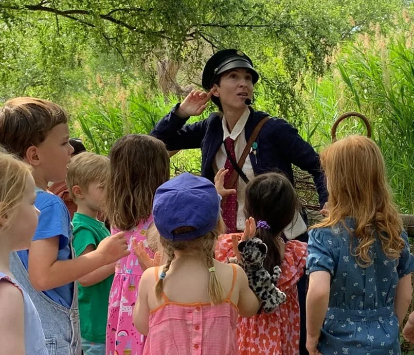 Children taking part in an outdoor storytelling session at a family-friendly literary festival in London.