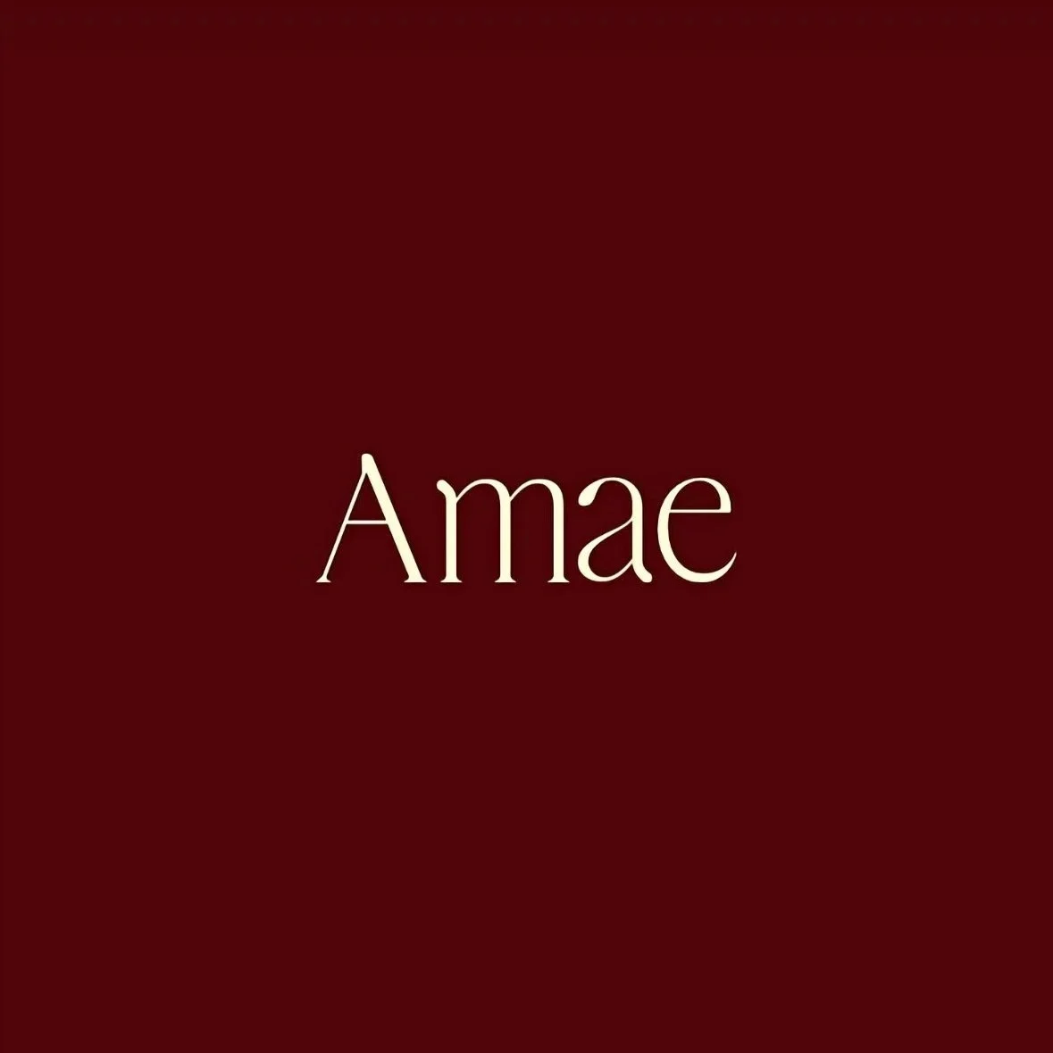 Amae brand logo in elegant serif typography on red background, minimalist children’s lifestyle brand identity