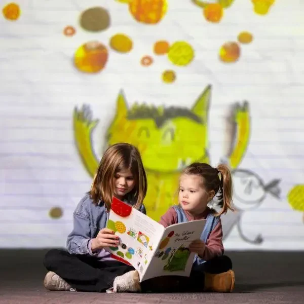 Children reading The Colour Monster book at immersive art exhibition, colourful interactive storytelling experience for kids