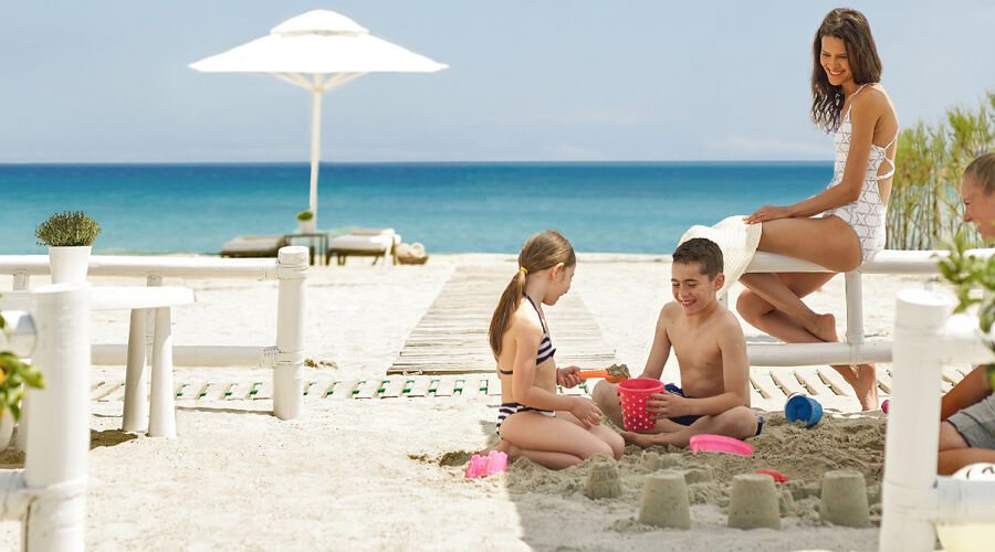 kids building sand castles while parents watch
