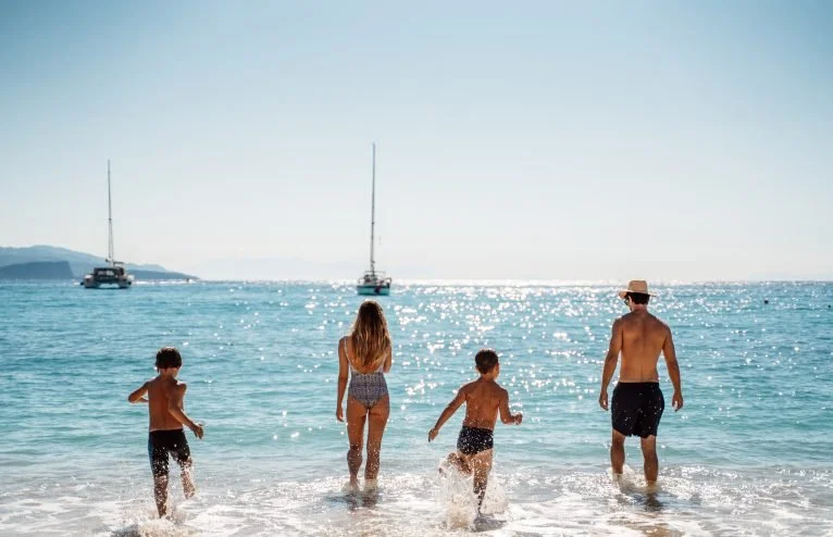 family heading into the sea to swim