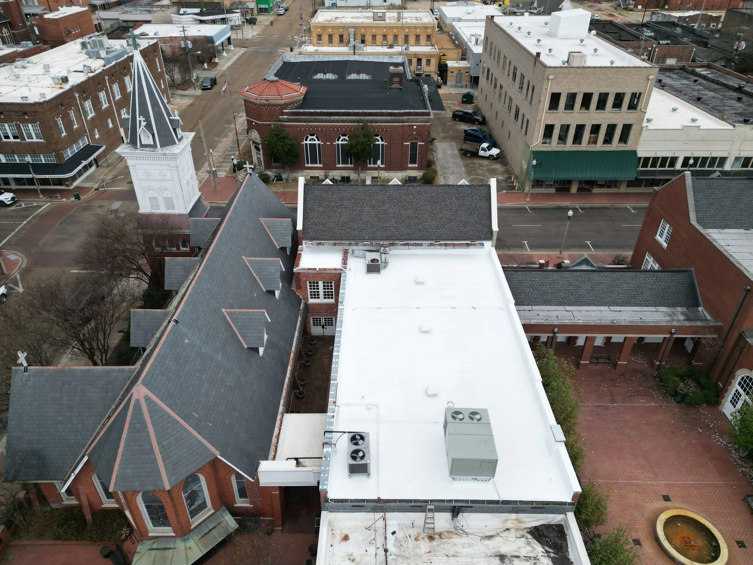 A newly installed white roof coating on a church roof