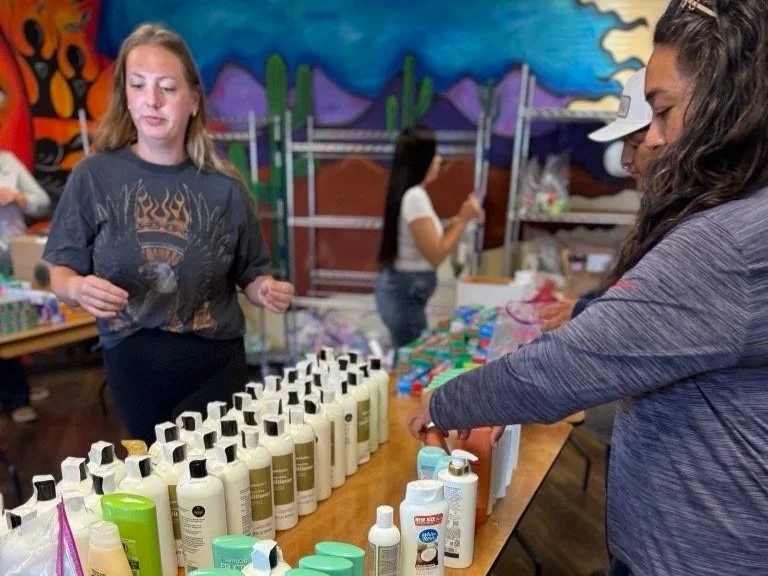 Volunteers organize bottles of shampoo
