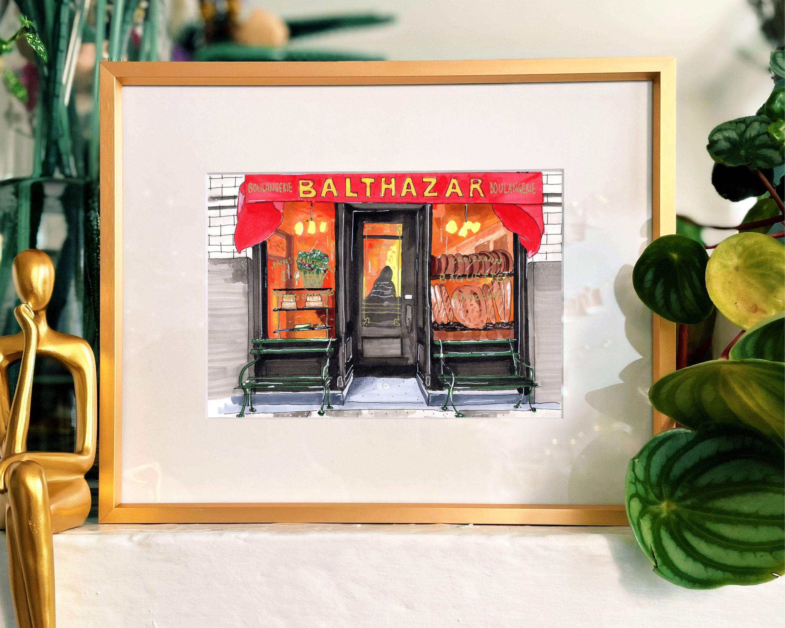 Framed in gold, this hand-illustrated drawing of Balthazar print sits on a mantelpiece