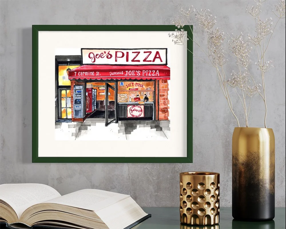 Framed in dark green, this hand-illustrated drawing of Joe’s Pizza, a Greenwich Village institution print hangs on the wall