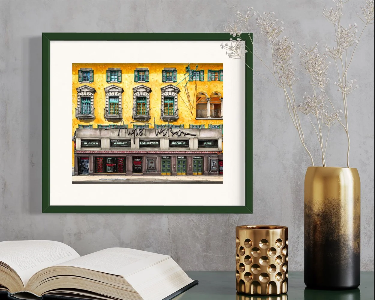 Framed in dark green, this hand-illustrated drawing of August Wilson Theatre with Paranormal Activity marquee print hangs on the wall