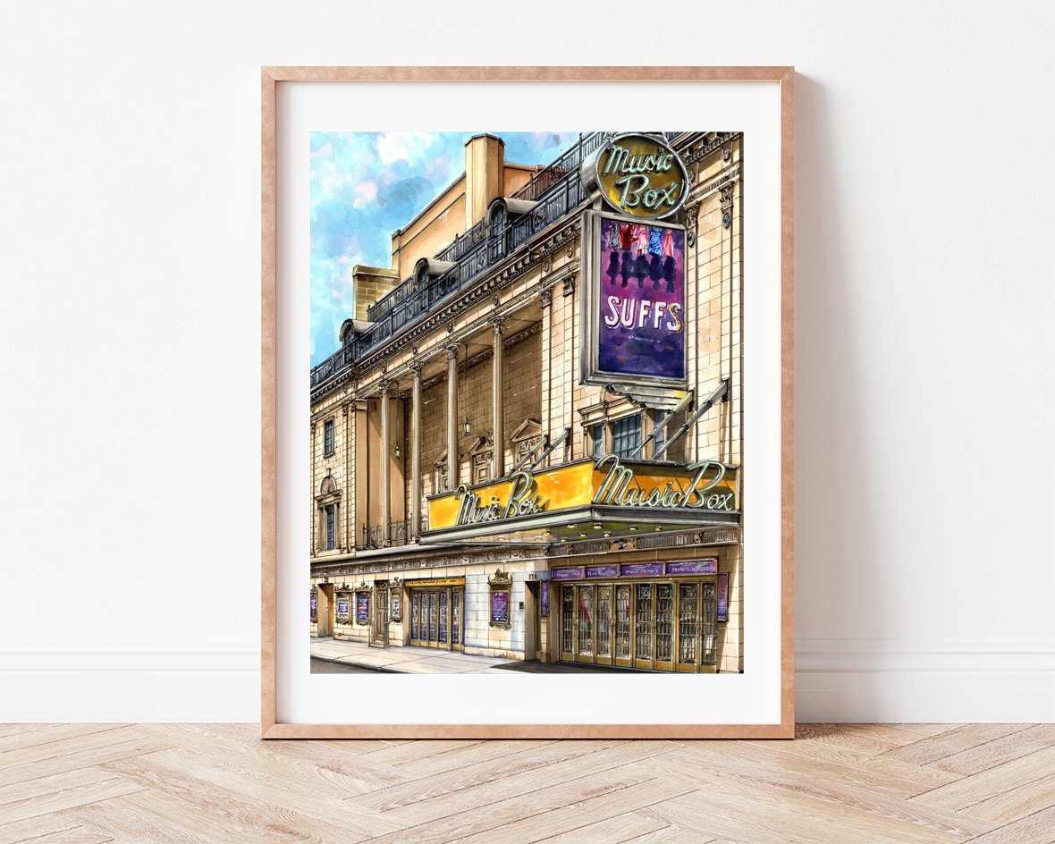 Leaning against a plain wall, Suffs at the Historic Music Box Theatre drawing sits in a slim light wood frame