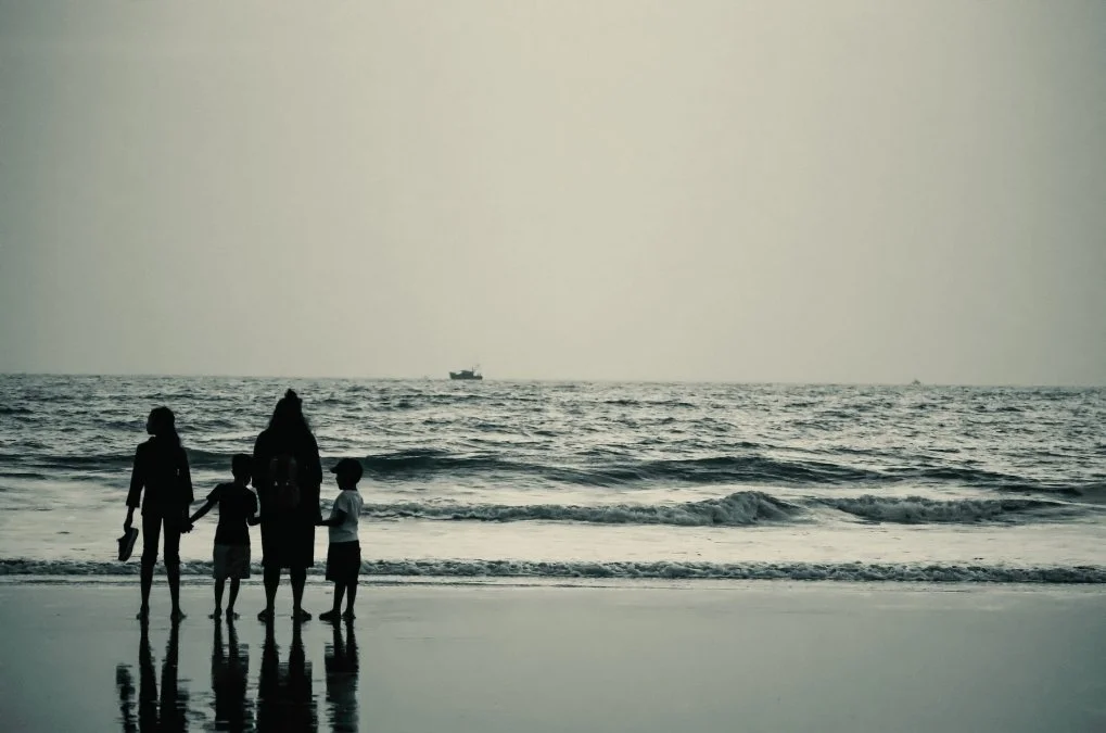 Soft abstract background of Silhouette of a mother and three children standing on the beach at dusk.for the section: what can  I expect in Matrescence therapy