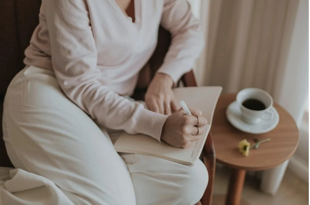 Soft abstract background of woman journaling with a cup of coffee for the section: What can I expect in therapy for anxiety and depression?