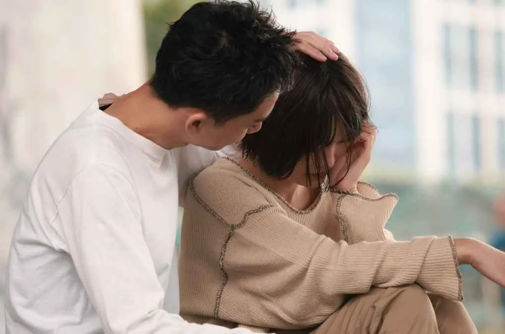 Man consoling a woman.