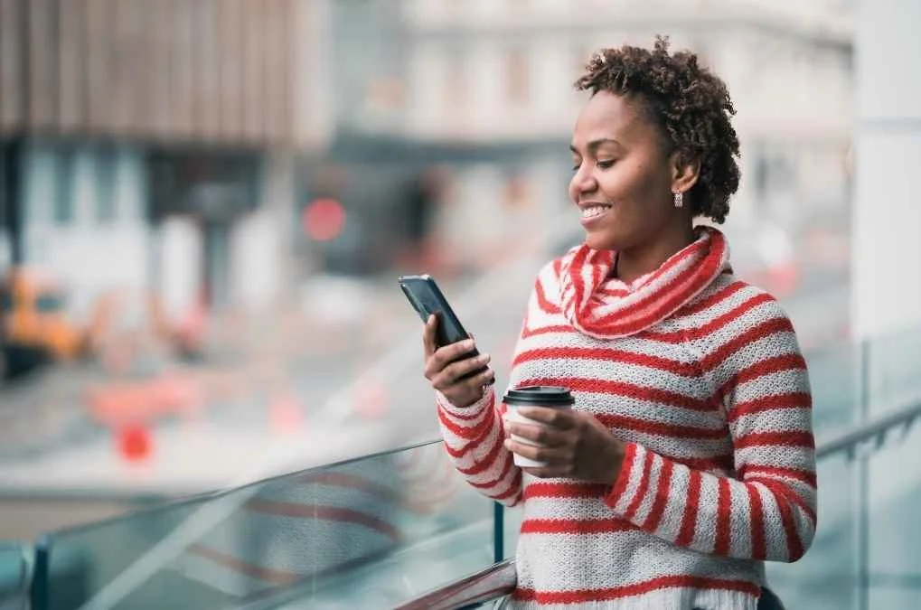 Woman smiling at her phone.