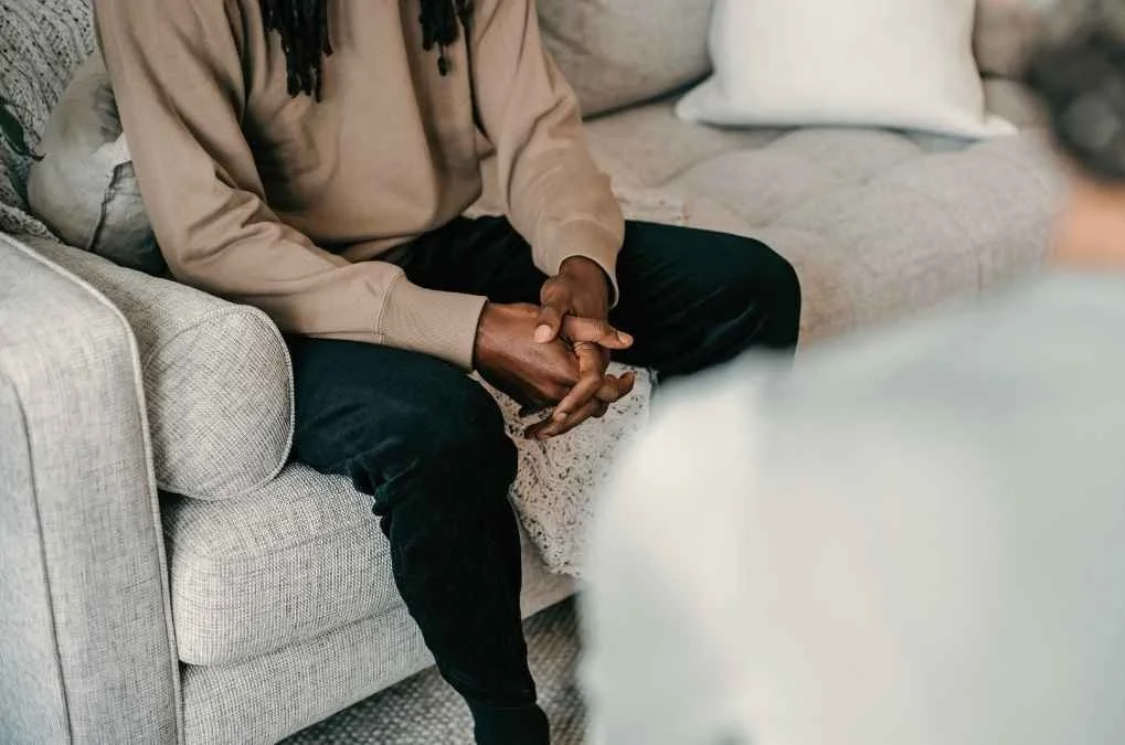 Man sitting with hands clasped.