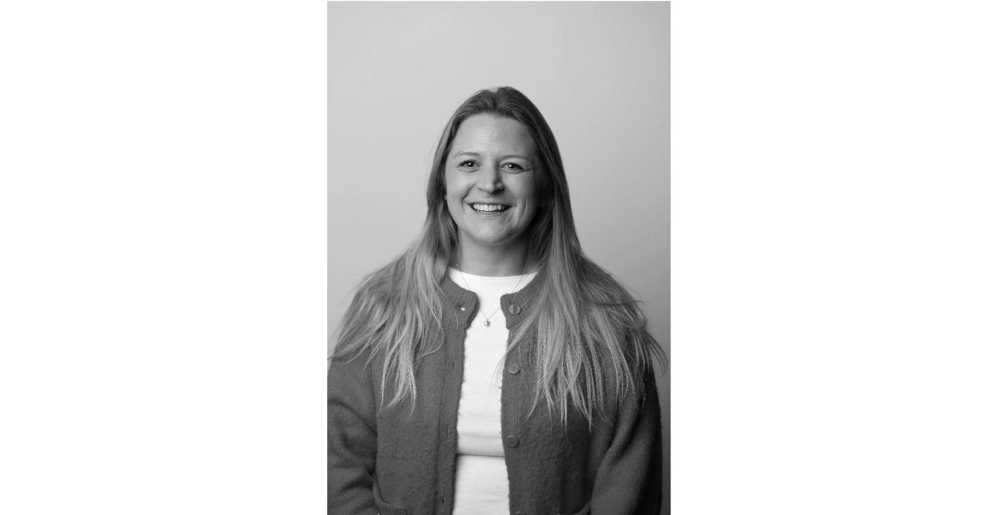 Black and white portrait of Lucy Collins beaming warm smile.
