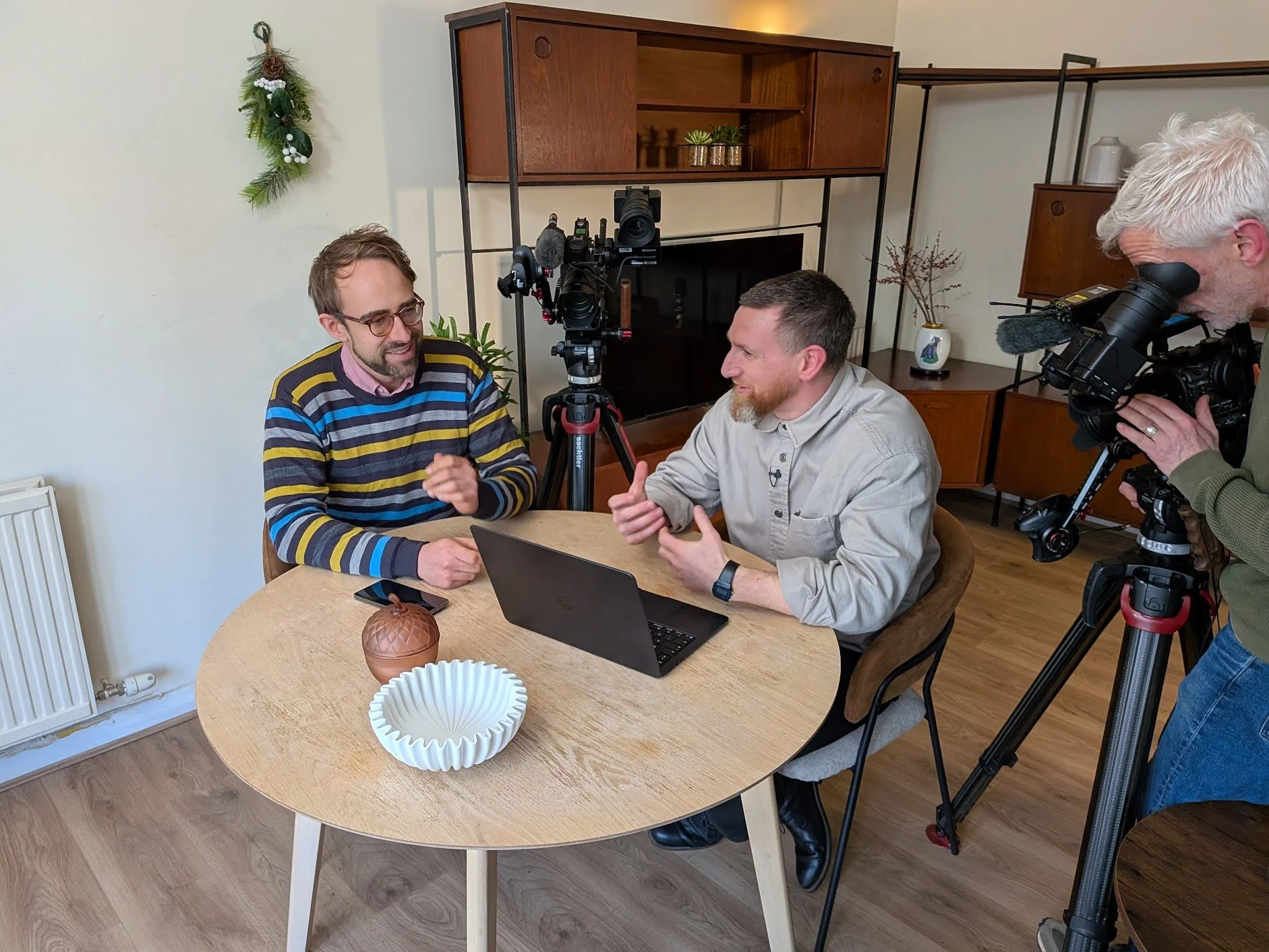 Two men sat, engaged in conversation in a dining room