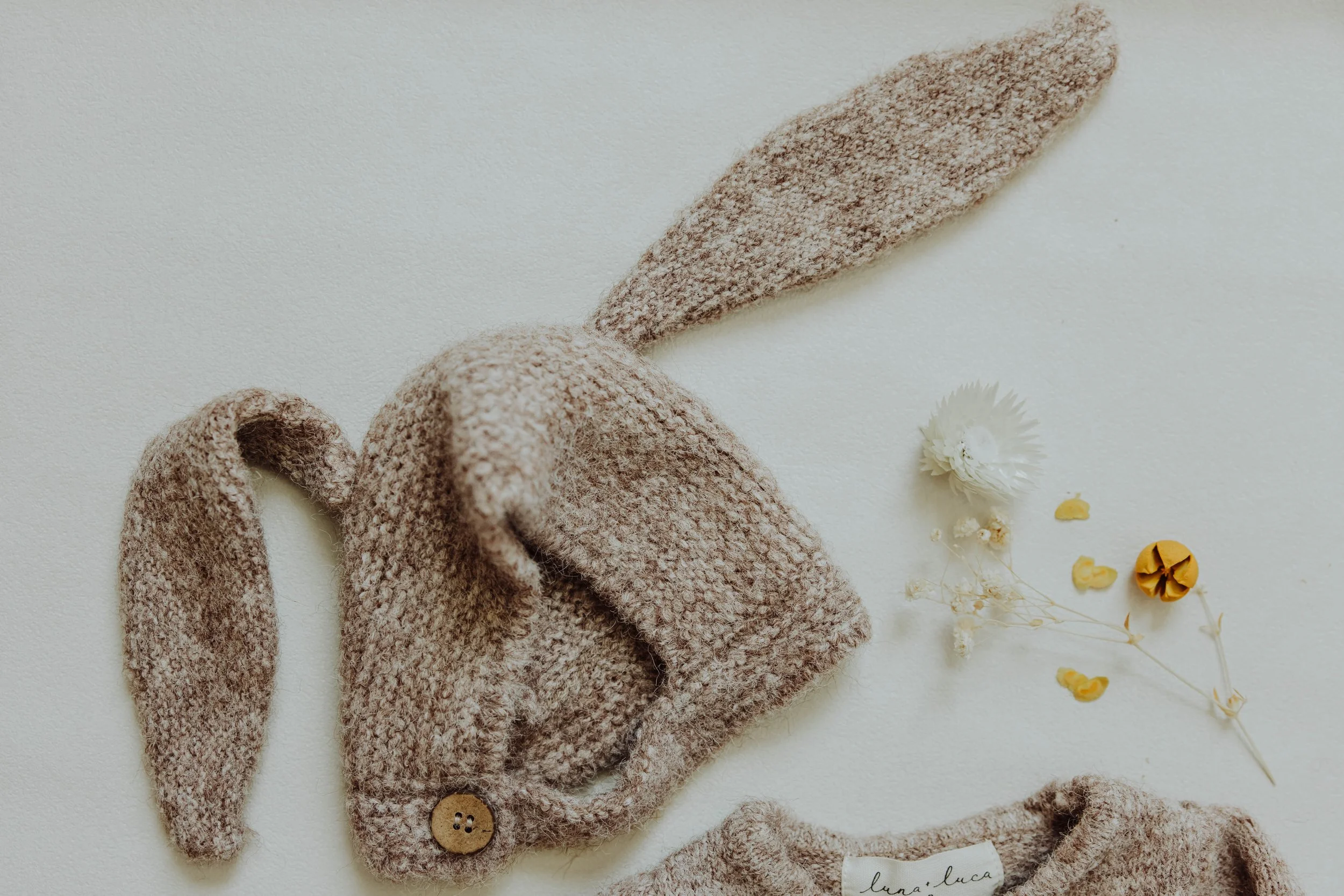   Detail product photo of children's clothing with natural light and textured styling props.  