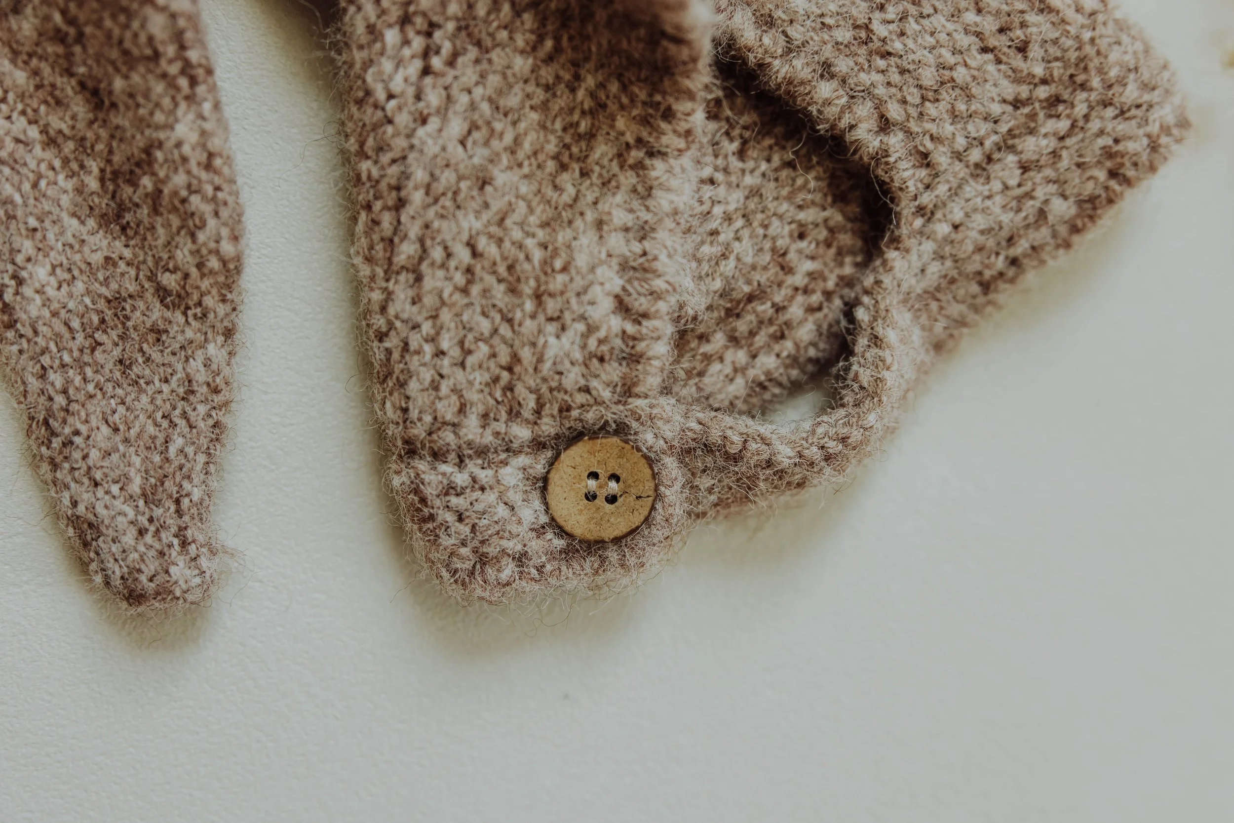   Detail product photo of children's clothing with natural light and textured styling props.  