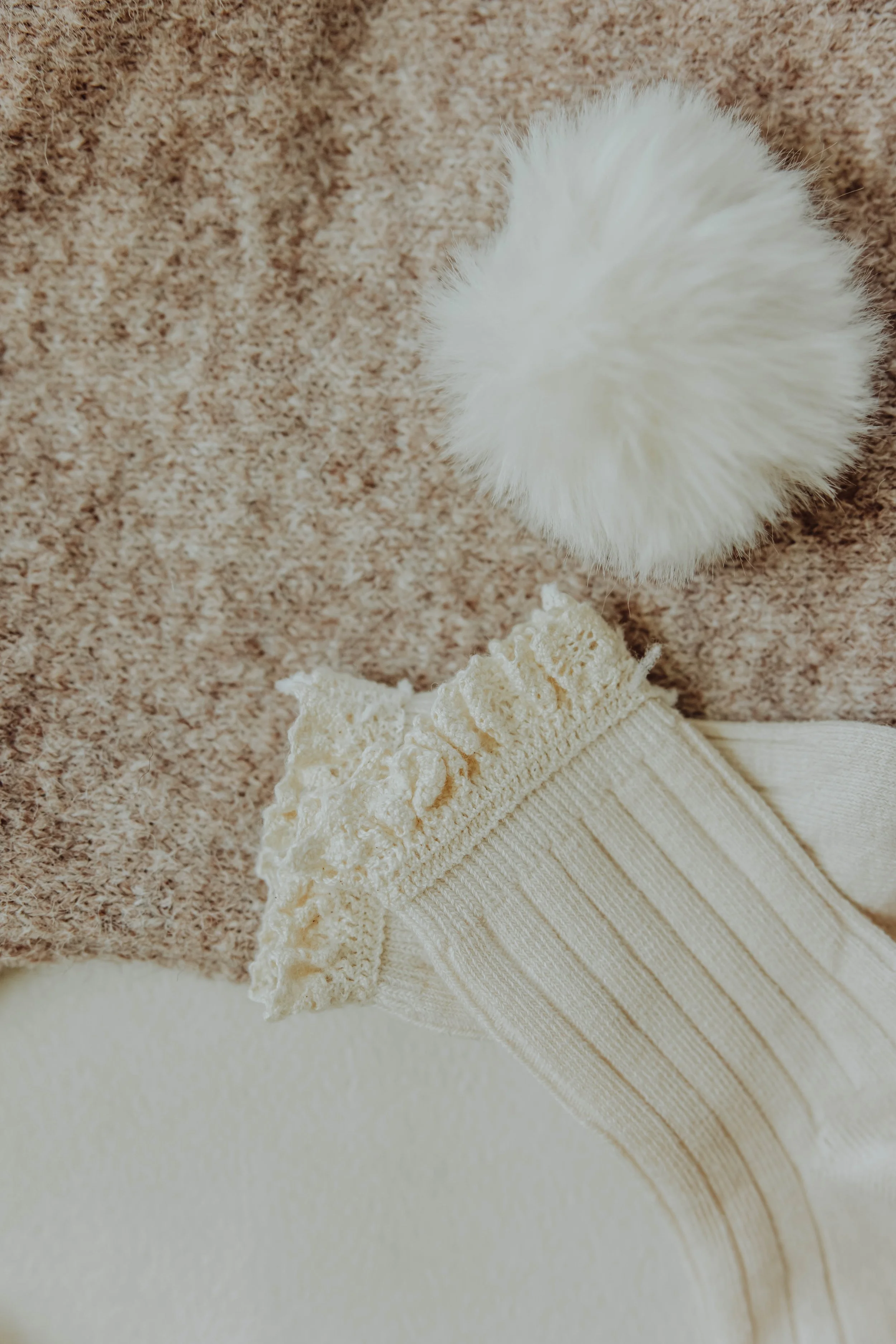   Detail product photo of children's clothing with natural light and textured styling props.  