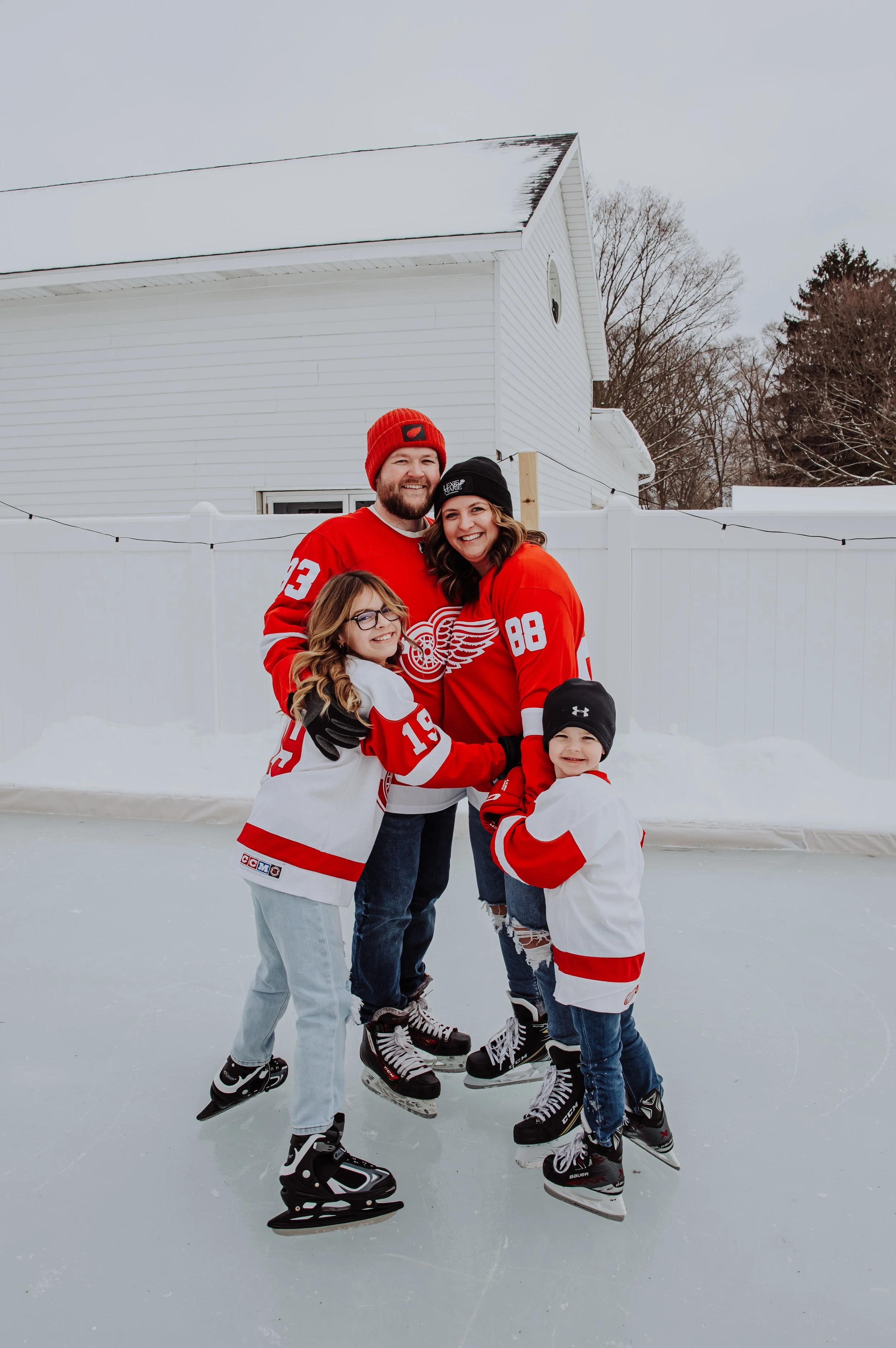 Lexie's family ice skating together in matching Red Wings jerseys