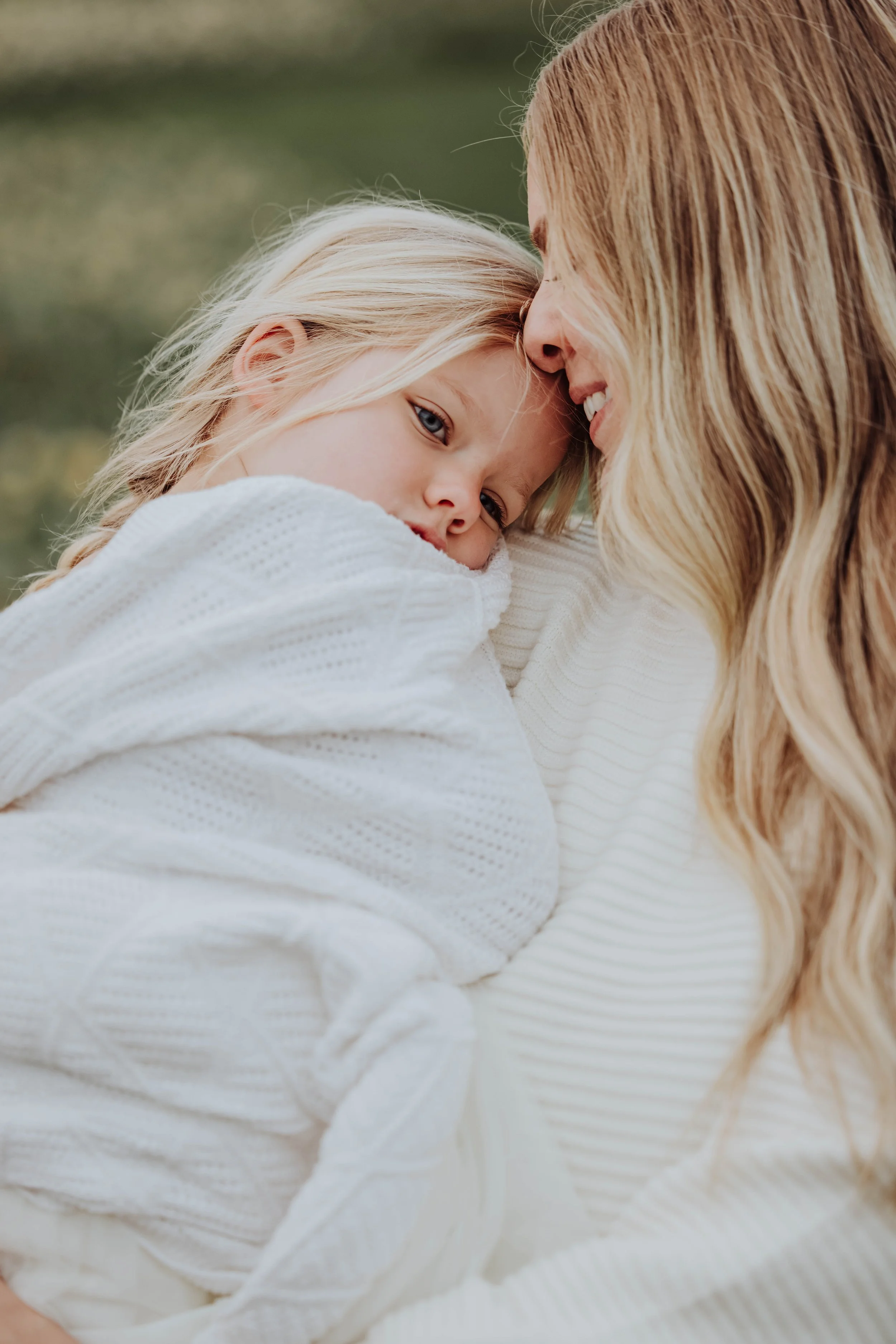 Mom and Daughter snuggling in Holland Michigan tulip field, lifestyle family photography by Lexie Marie Photography.