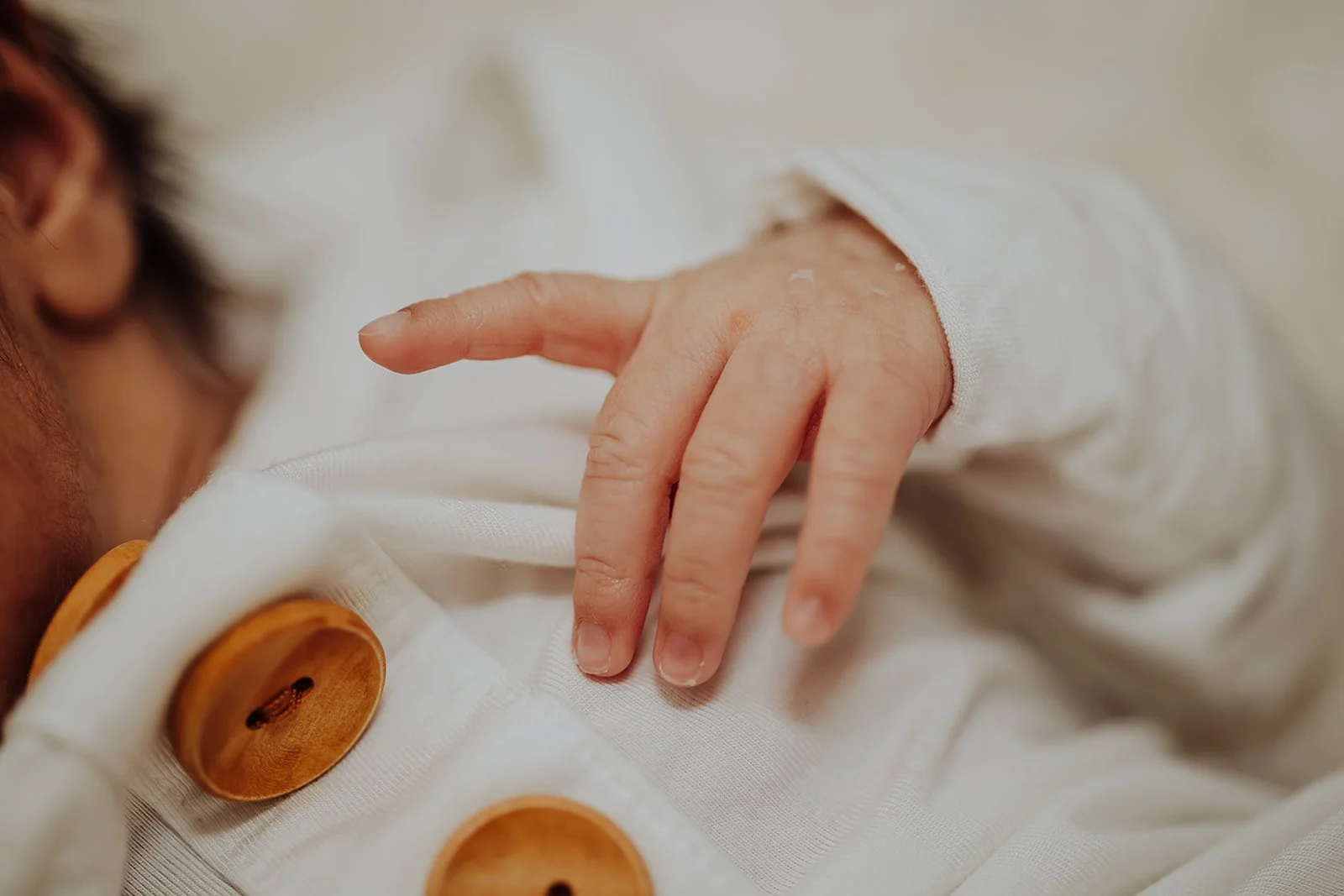 Newborn detail photo of baby's hand in parent's hand, taken by West Michigan newborn photographer Lexie Marie Photography