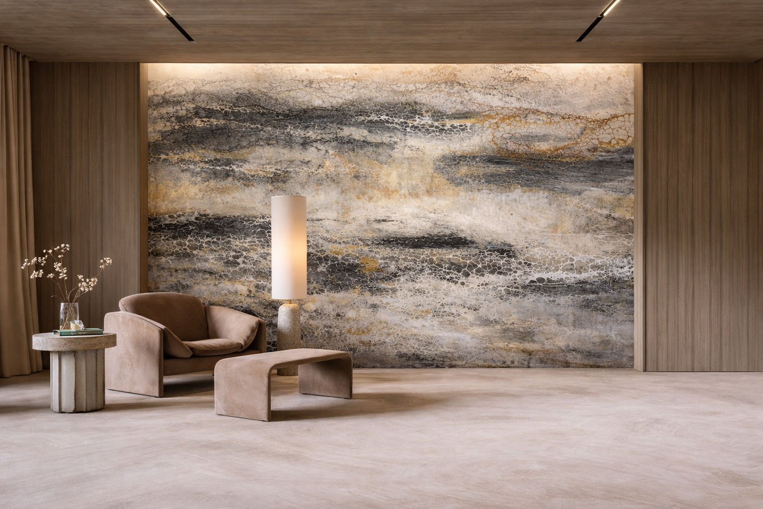 Modern living room with a large abstract art mural on the wall, a beige armchair with matching ottoman, a side table with a vase of white flowers, and a tall floor lamp.