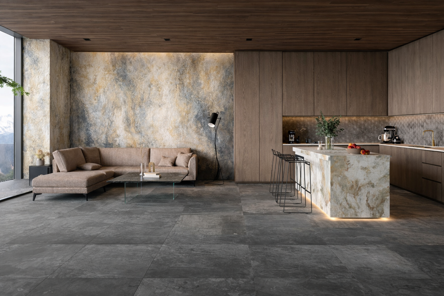 Modern, open-concept living area with a beige sofa, glass coffee table, textured wall, and a kitchen with a marble island, wooden cabinets, black bar stools, and view of mountains outside.