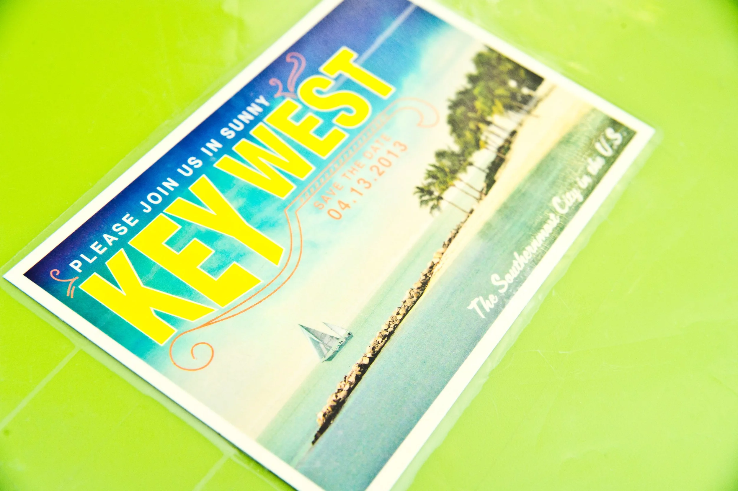 A colorful travel advertisement with the word "YES!" in large yellow letters and a scenic coastal photograph with palm trees, sailboats, and a bright sky.