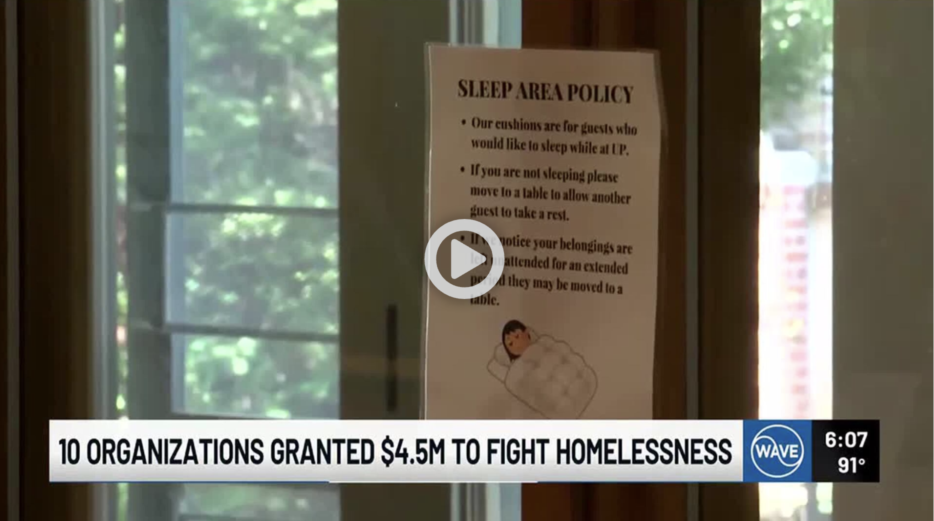 Sign in a room with a window showing trees outside, displaying a sleep area policy for guests, with a cartoon illustration of a person sleeping in a bed.