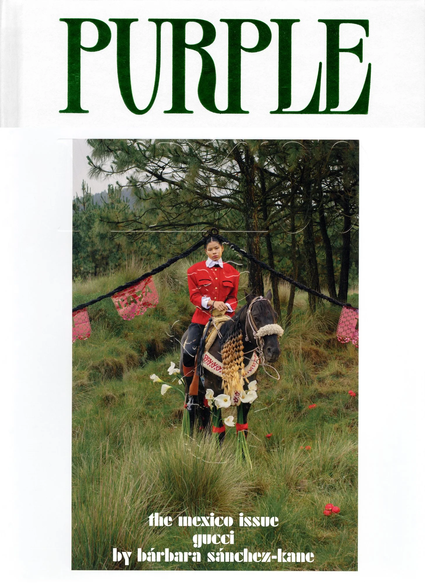 Cover of Purple magazine featuring a woman in a red jacket riding a horse through a grassy field with trees in the background; the horse is decorated with white flowers and colorful textiles.