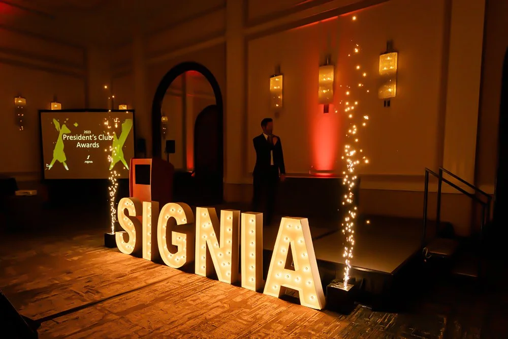 corporate awards ceremony with illuminated event signage and stage effects