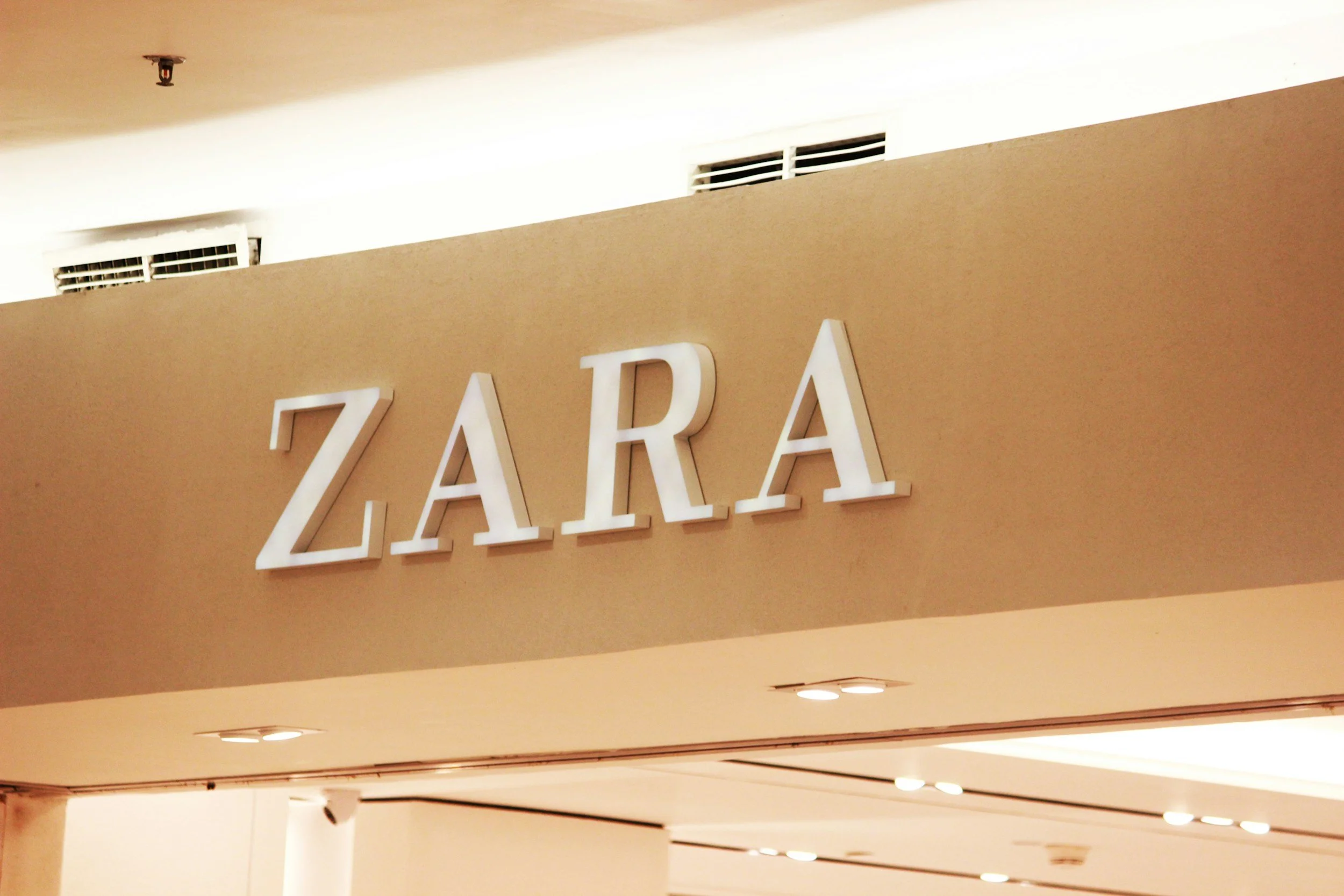 Zara store sign with large white letters on a beige background.