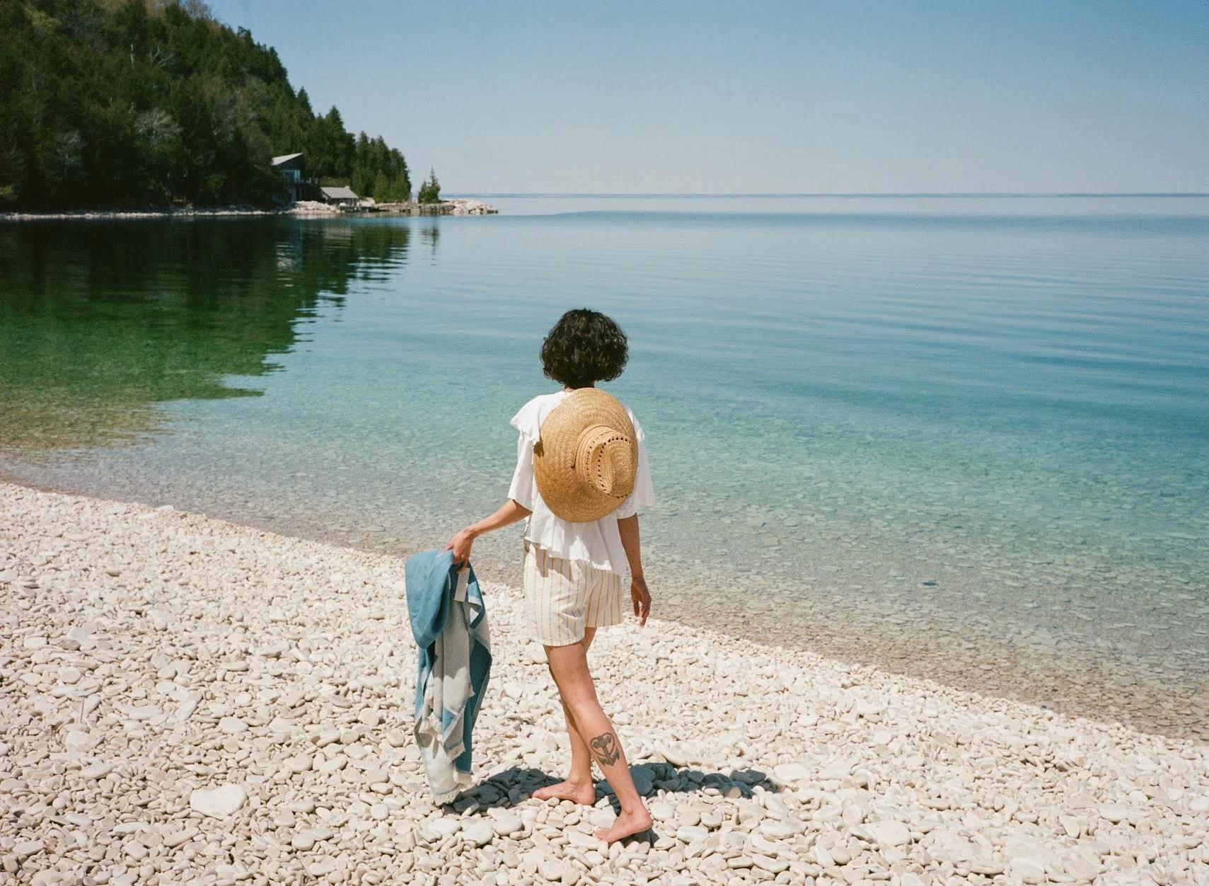 Long shot image woman walking by the lake