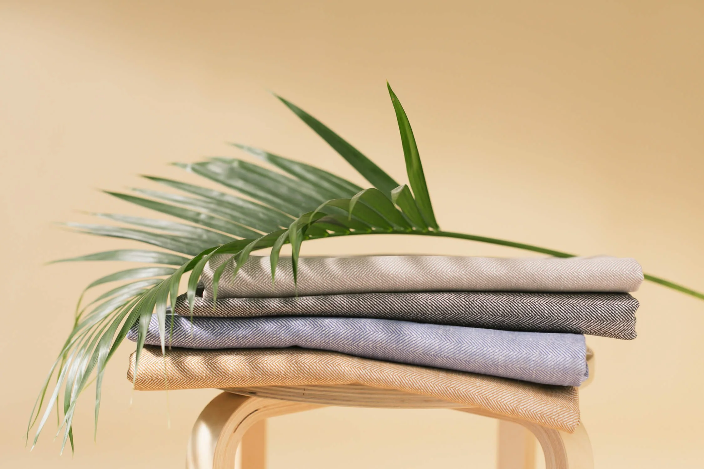 folded linen fabric with a palm leaf laid on them