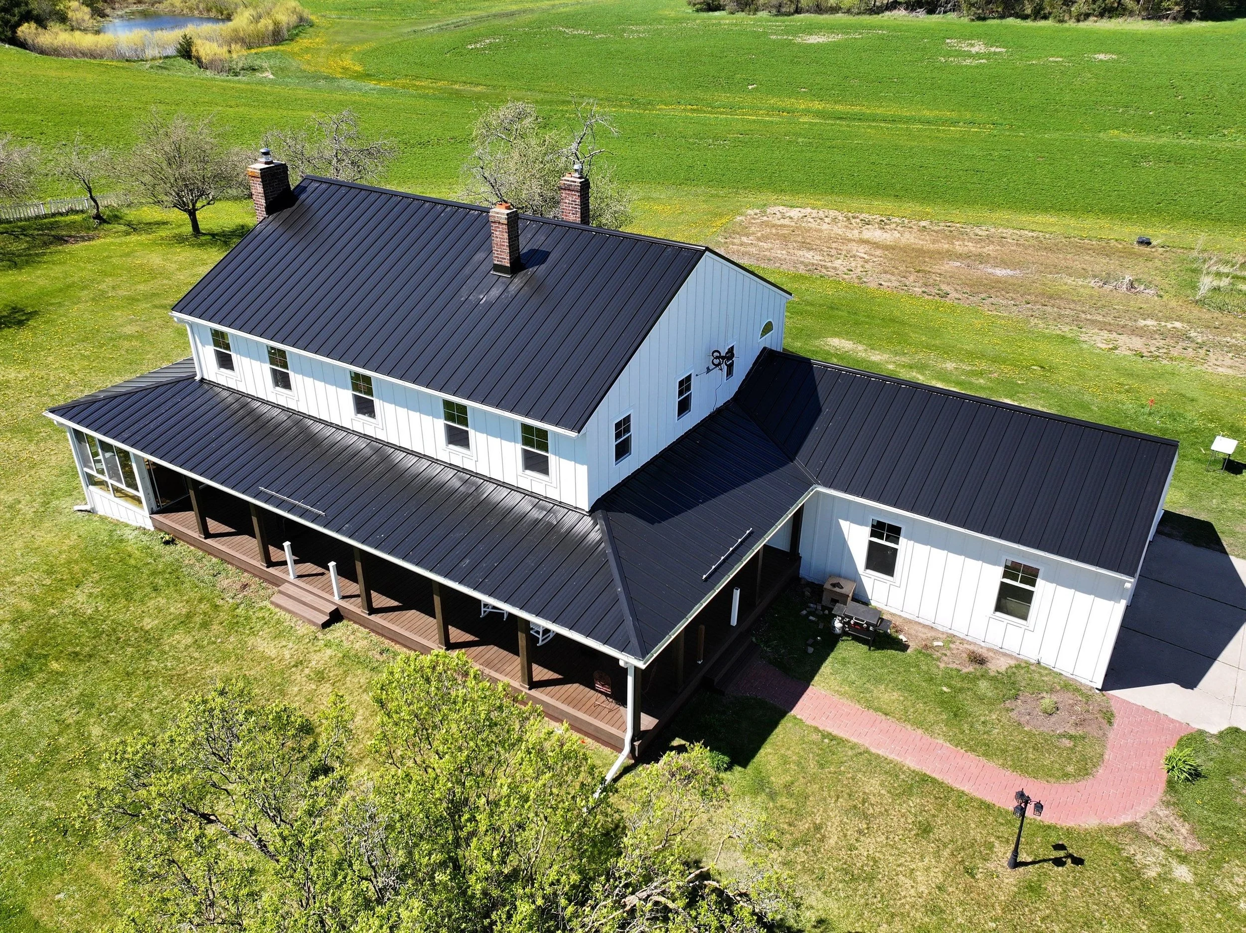 black standing seam roof in pound, wisconsin on a sunny spring day surrounded by lush landscape