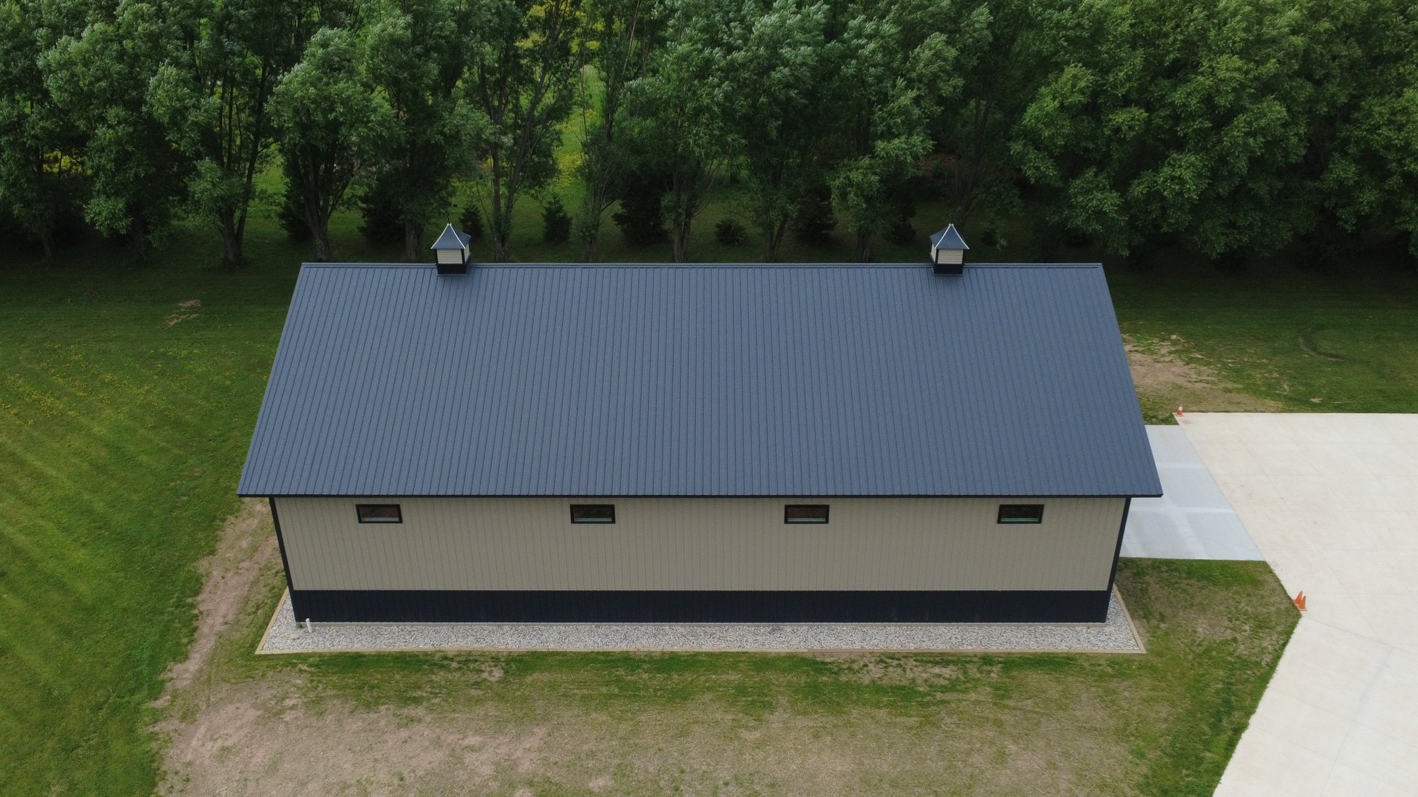 Clay board and batten shed with black wainscot and trim accents and black standing seam roof in Kaukauna Wisconsin