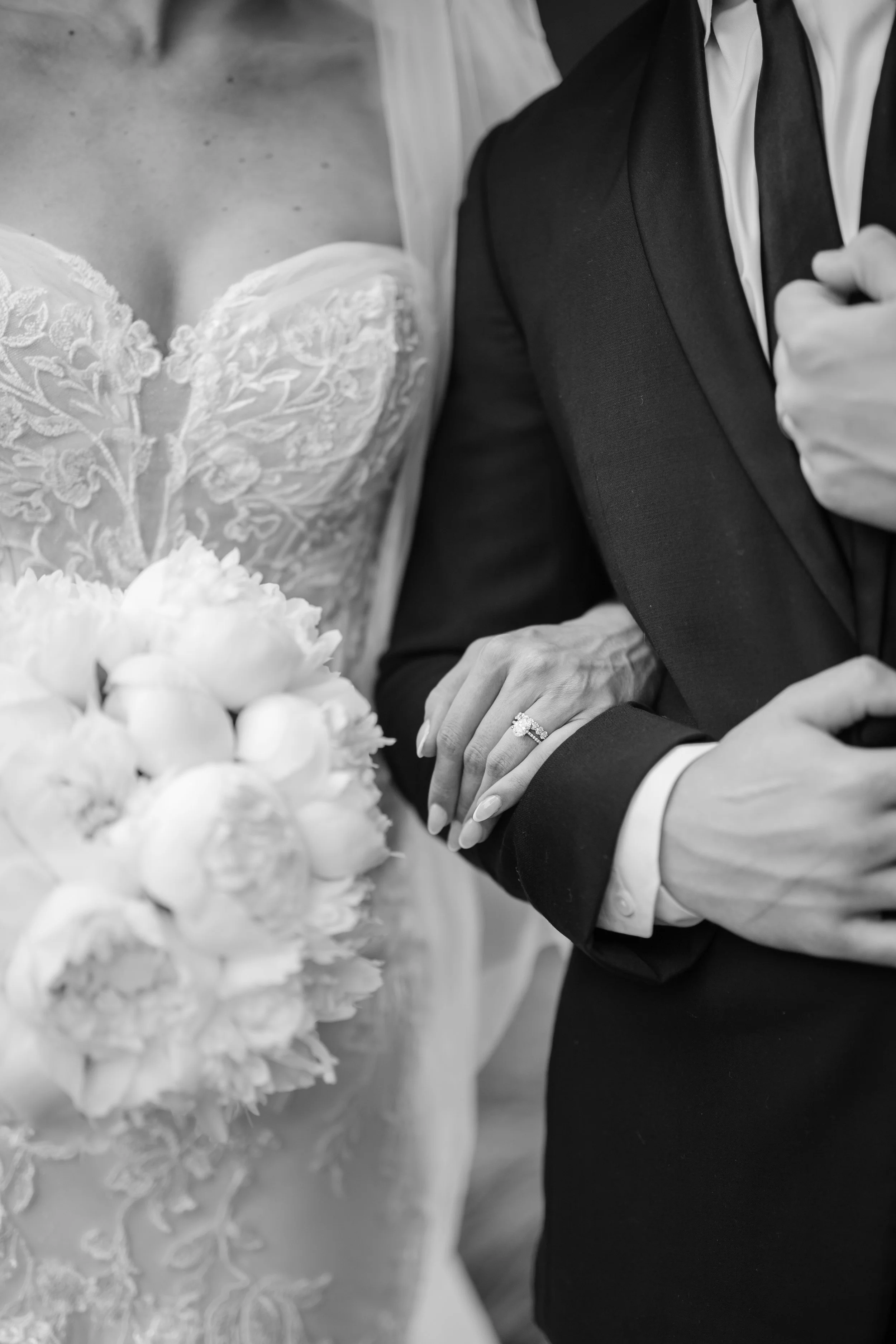 A bride and groom holding hands, with a wedding dress and bouquet of flowers visible in the scene.