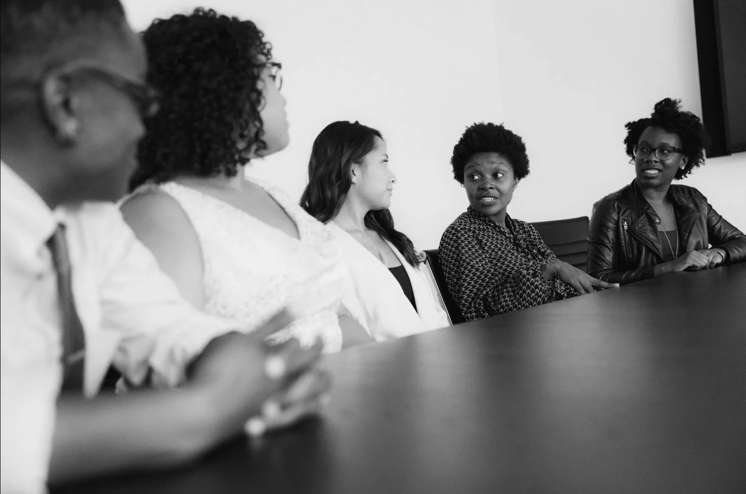 black and white. photo of adults learning at a conference table in a professional development setting