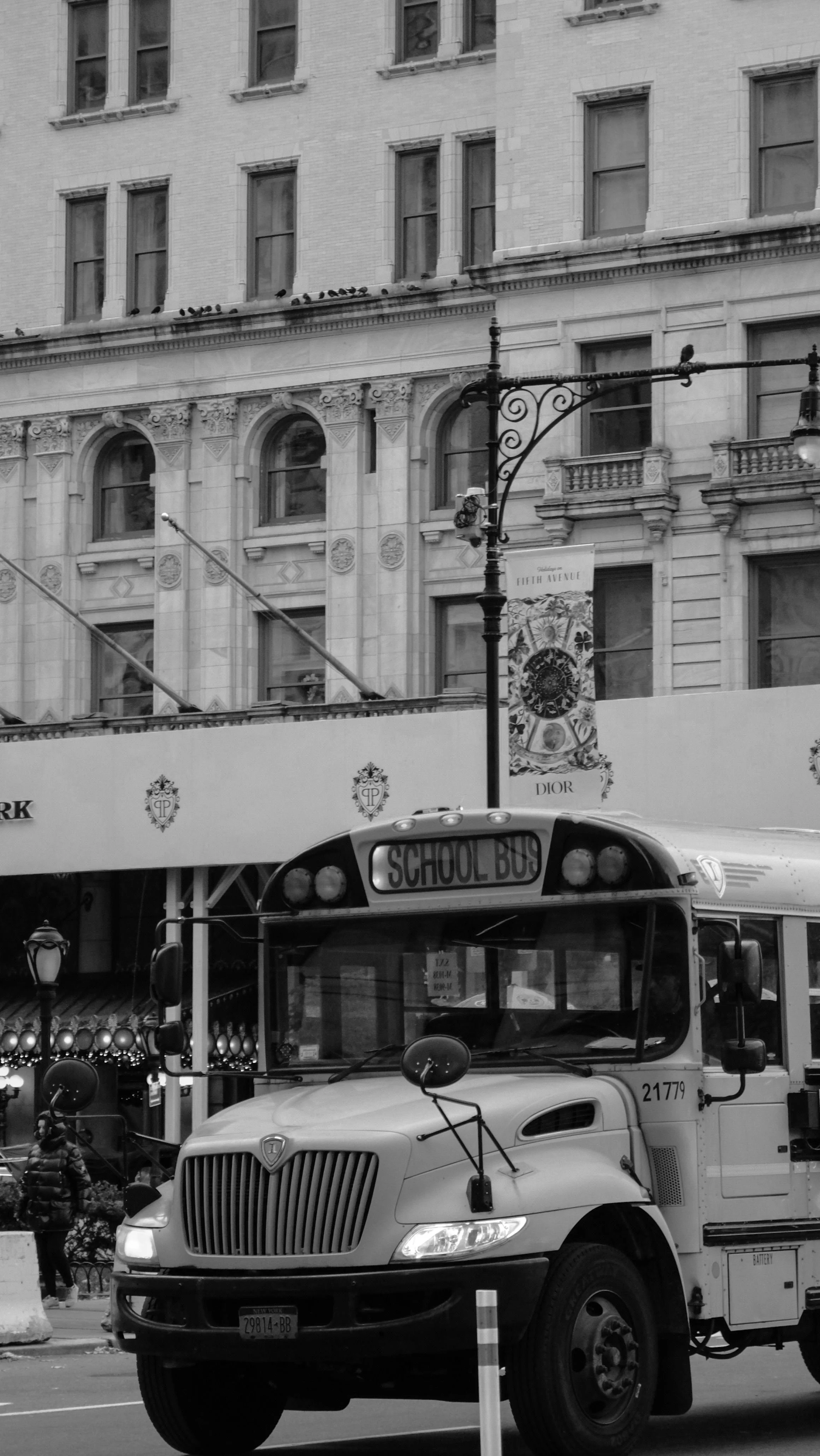 black and white photo of a school bus in an urban setting