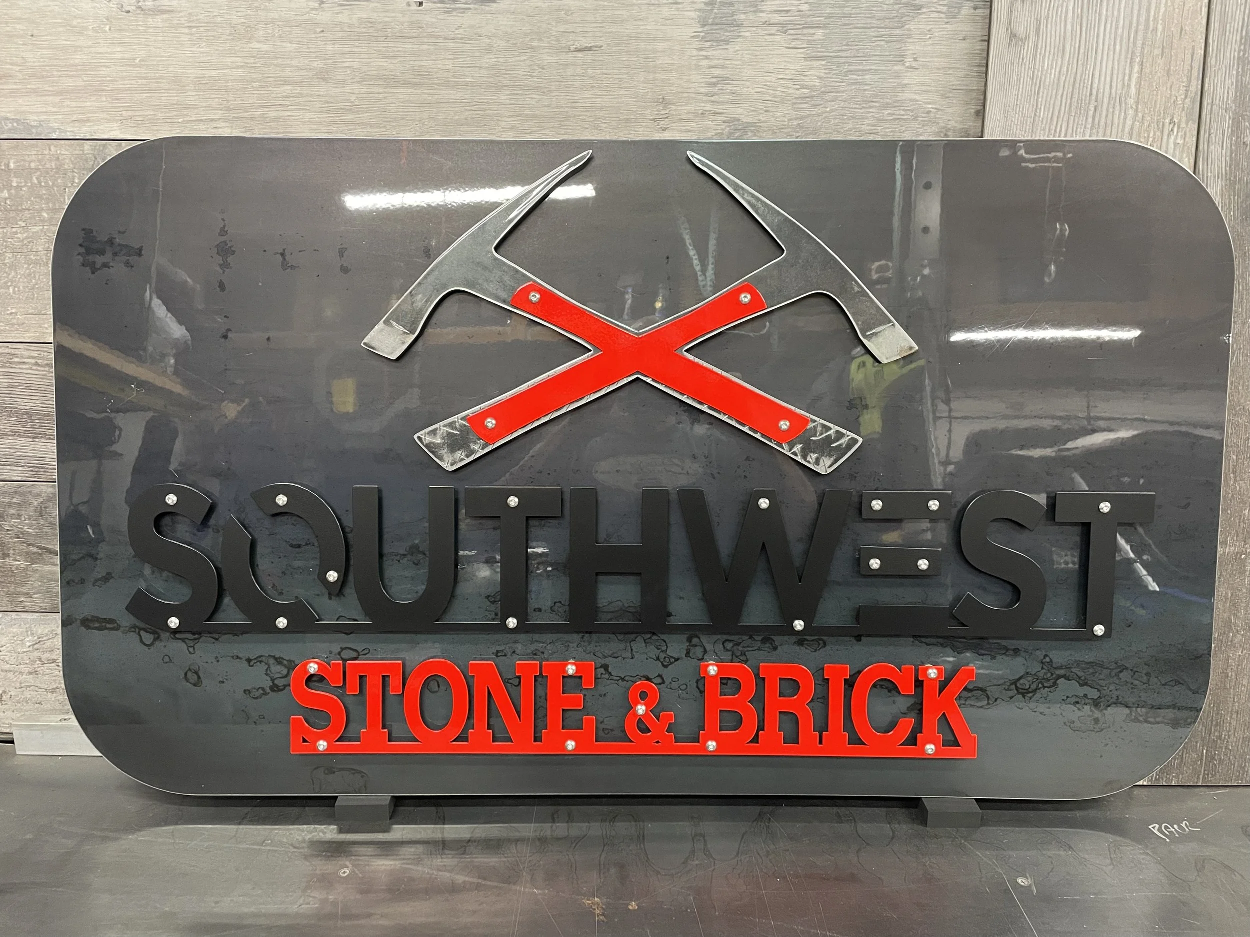 3-Layer Hot Rolled Steel Sign with red and black powder coating, cleared base layer with exposed bolts and hidden hanging holes.
