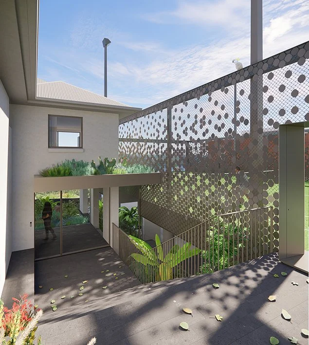 Modern multi-story building with outdoor stairwell and decorative metal screens, greenery, and a clear sky.