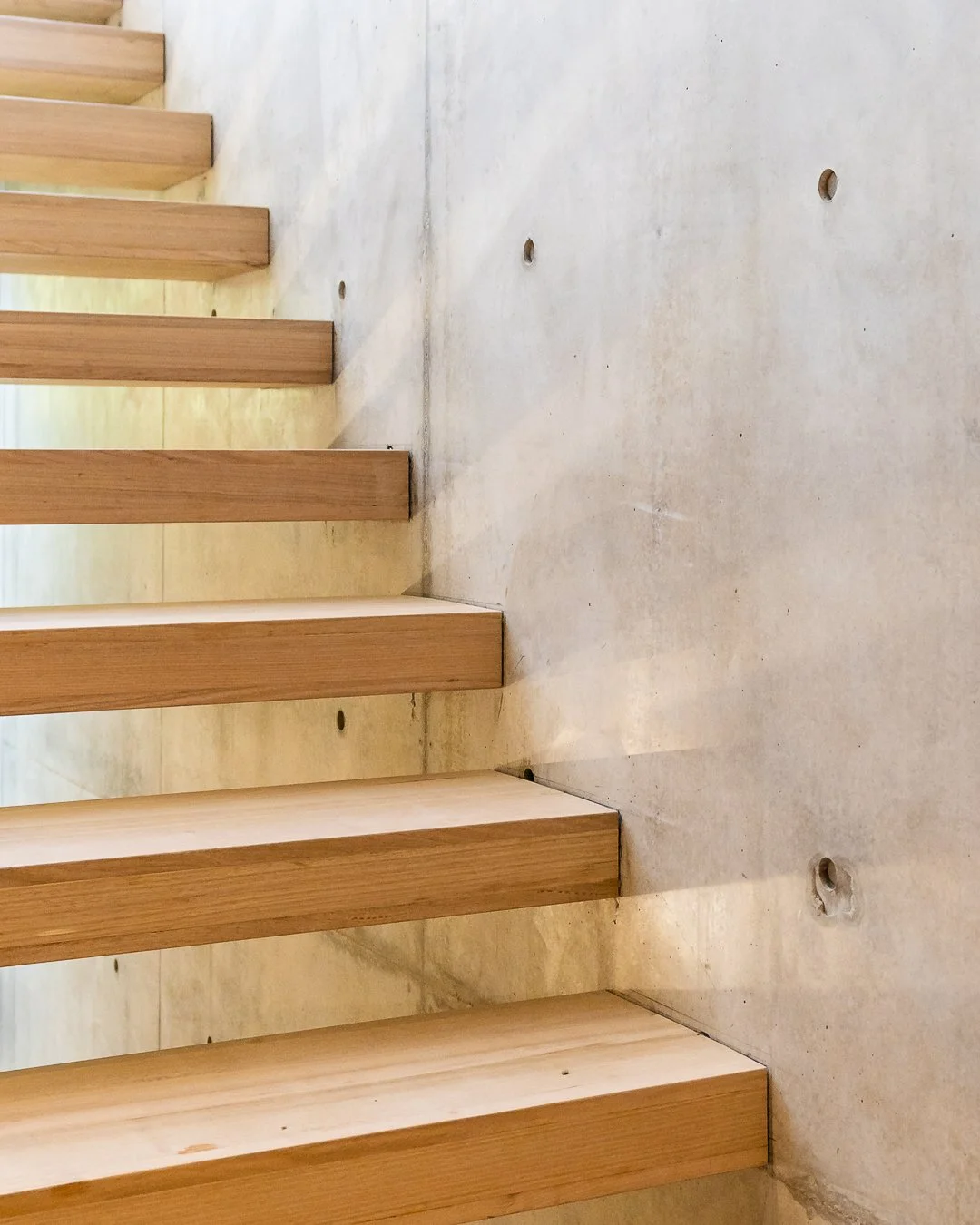 Close-up of wooden beams attached to a concrete floor with visible screw holes.